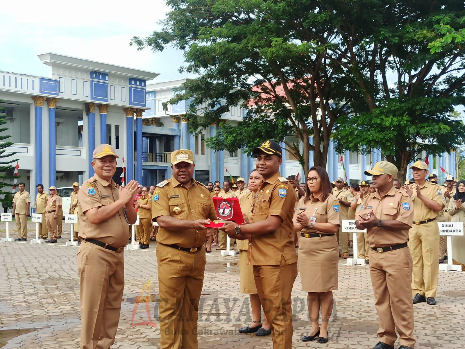 Bupati Hermus Indou menyerahkan penghargaan kepada Lurah Padarni Paul Rumbruren atas prestasi yang diraih
